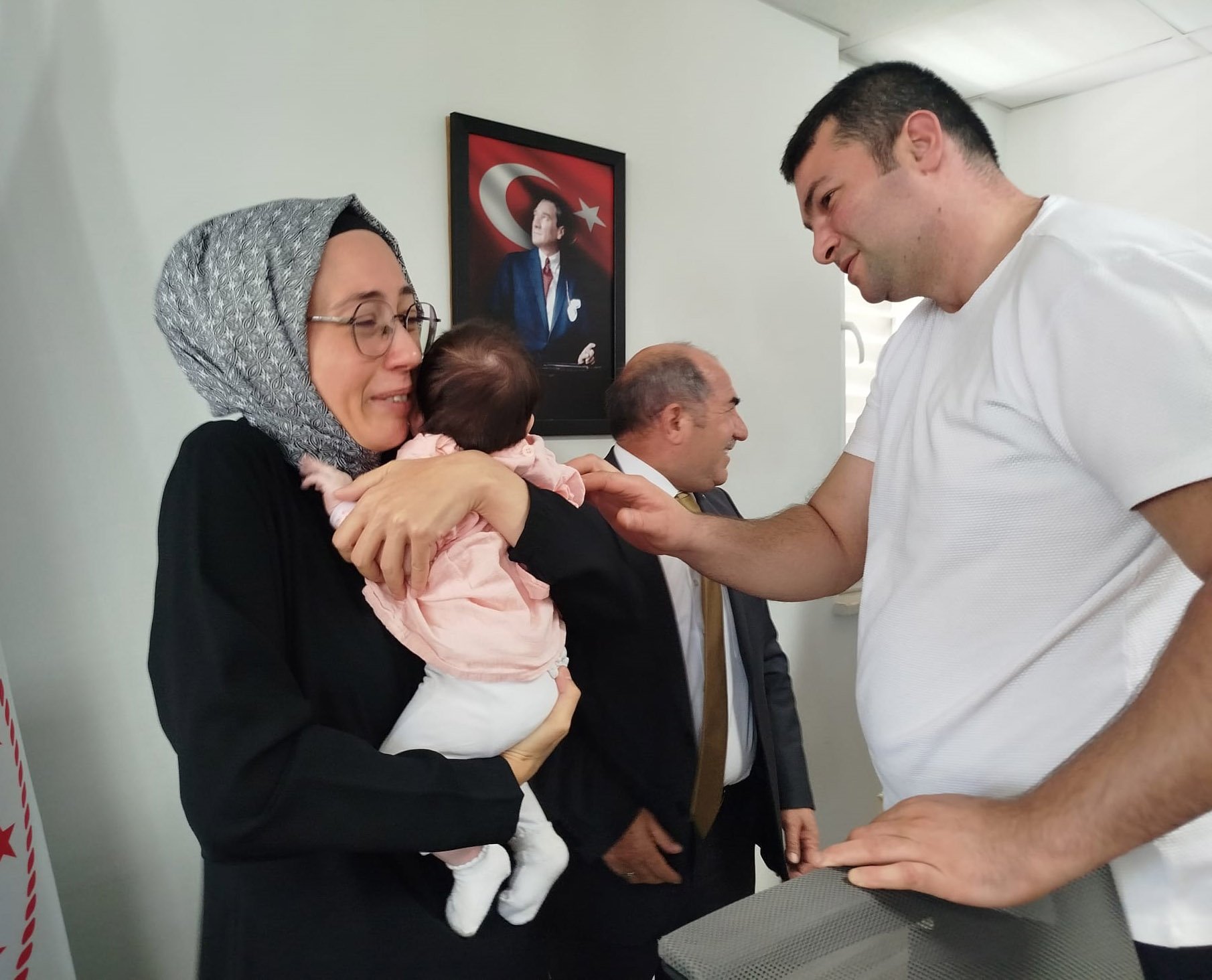 Hatice İlhan Begüm bebeği kucağına alırken