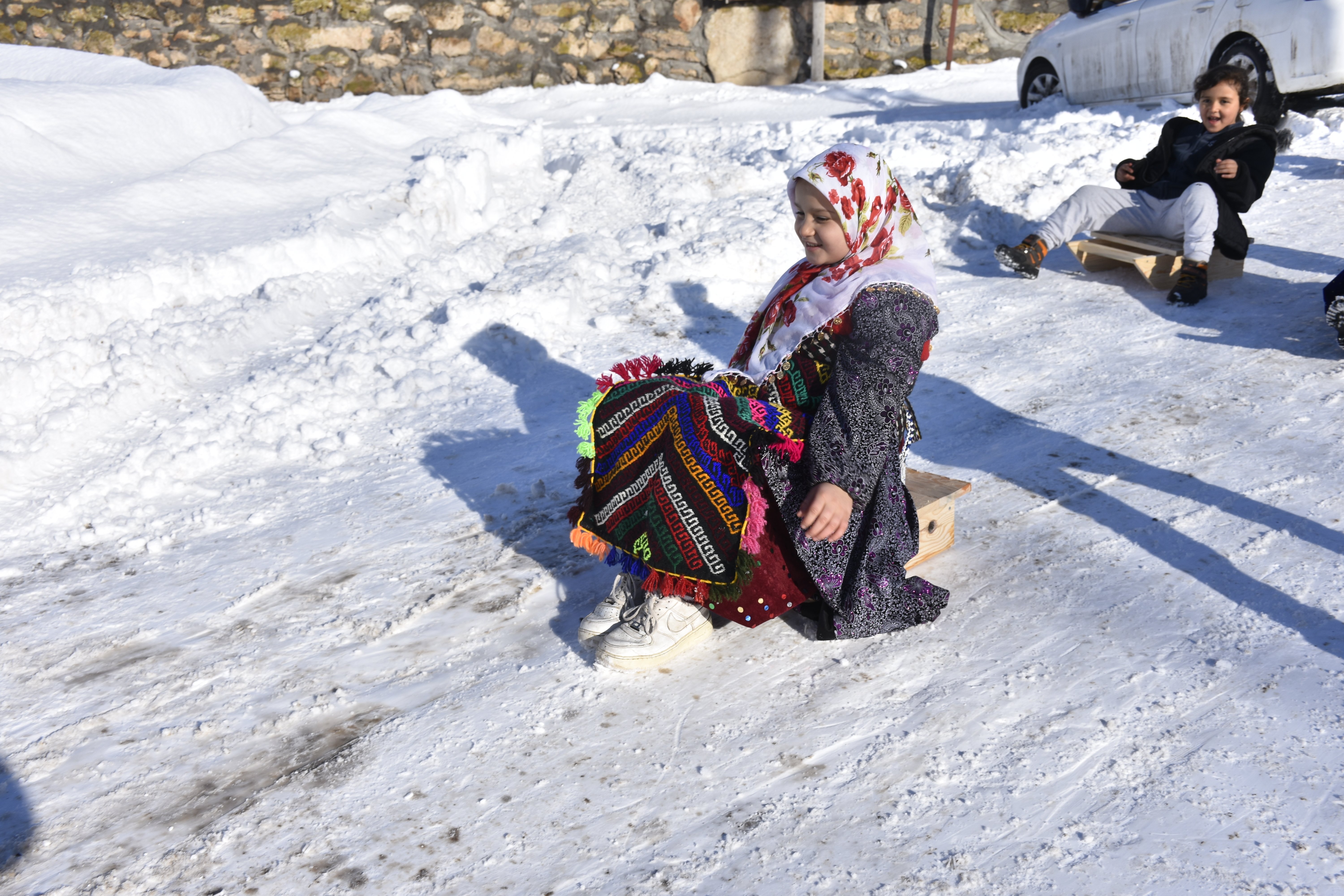 Çocuklar kızaklarıyla kayarken
