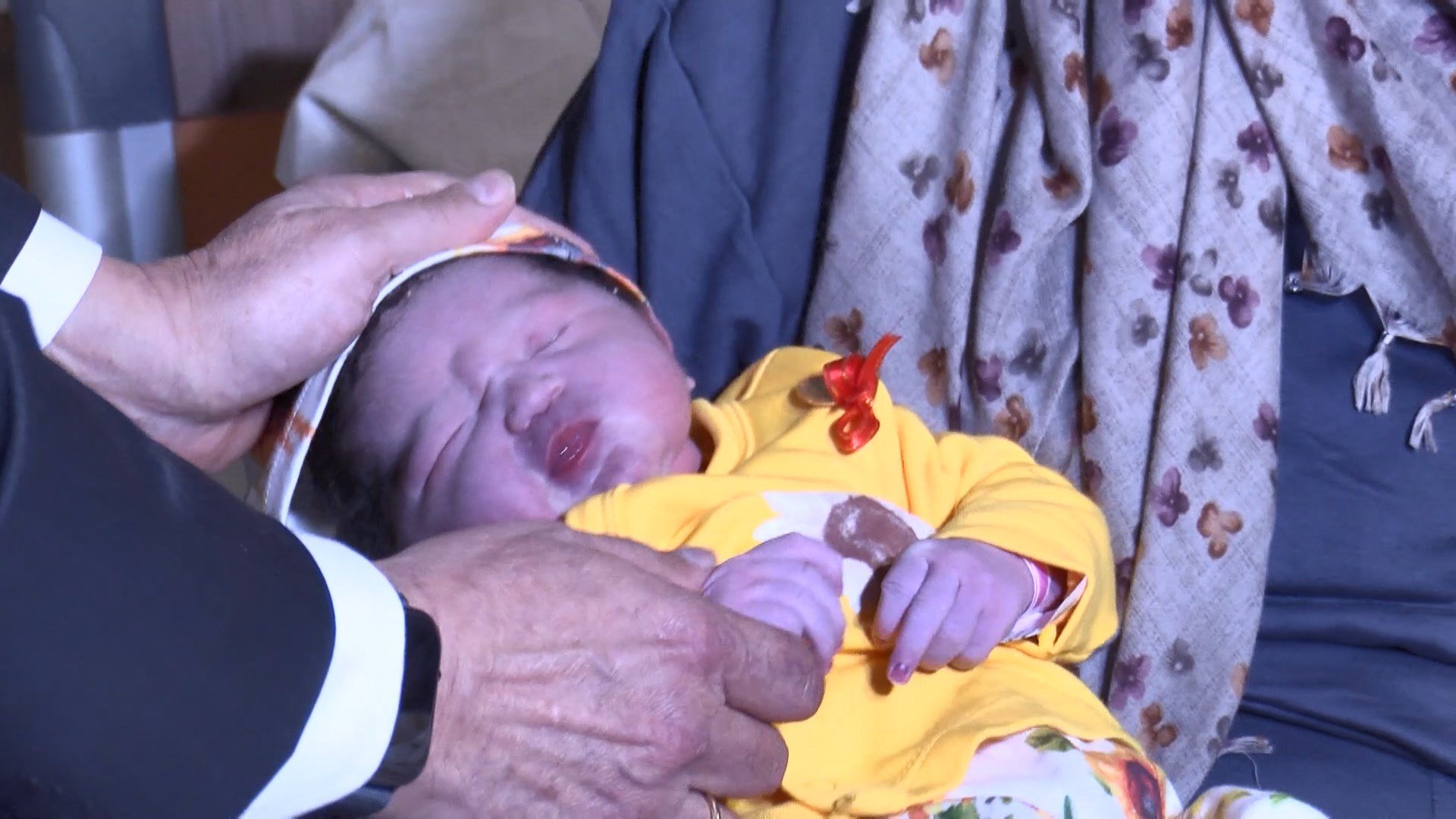 Bakan Memişoğlu Arya bebeği kucağında tutarken