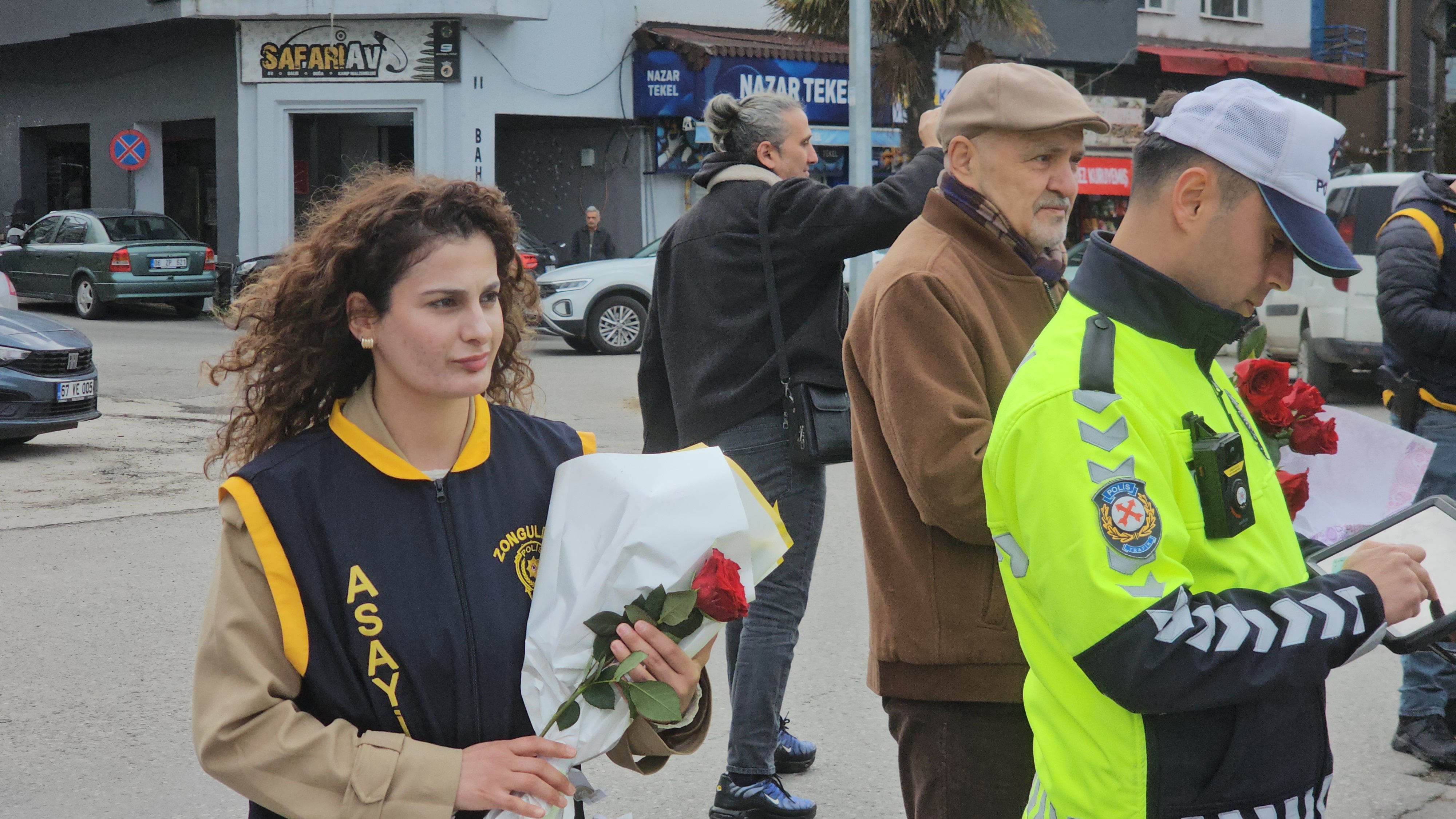 Polis memuru çiçekle araç kontrolü yapıyor