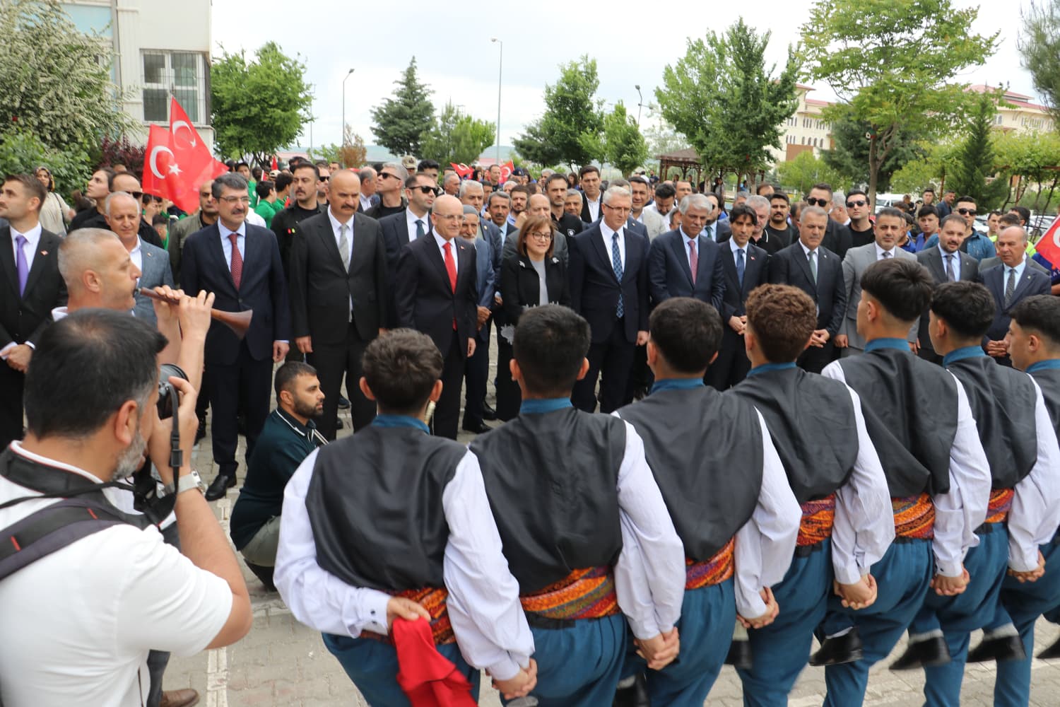 Bakan Şimşek ve protokol üyeleri, yapay zeka atölyesinin açılış kurdelesini kesiyor.