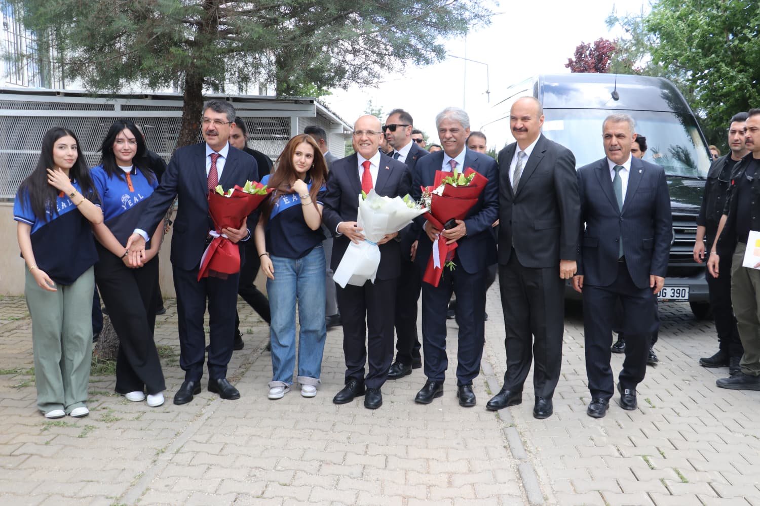 Bakan Şimşek ve beraberindekiler, tiyatro binası önünde hatıra fotoğrafı çektiriyor.