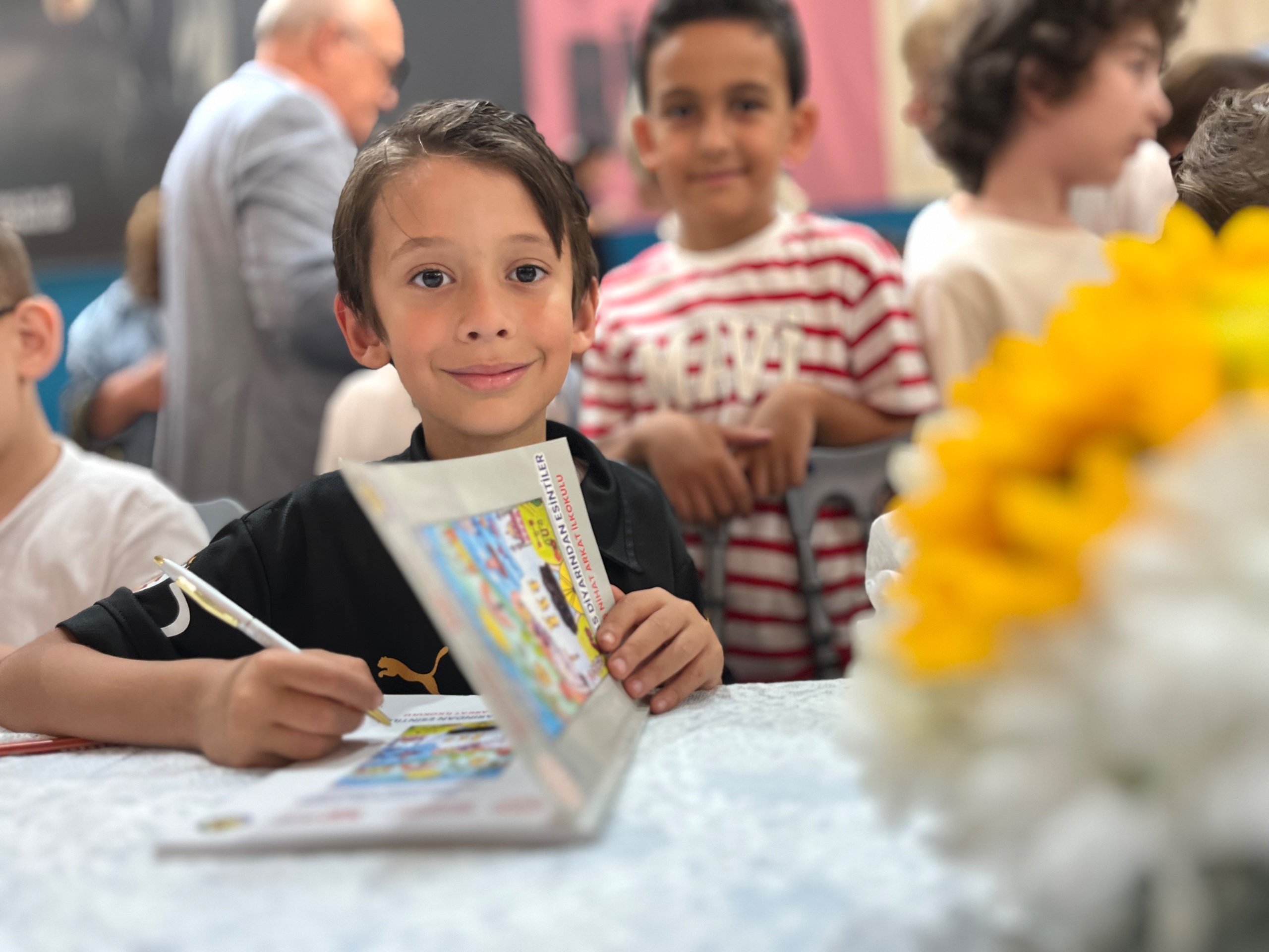 öğrenci yazarlar kitaplarını imzalarken