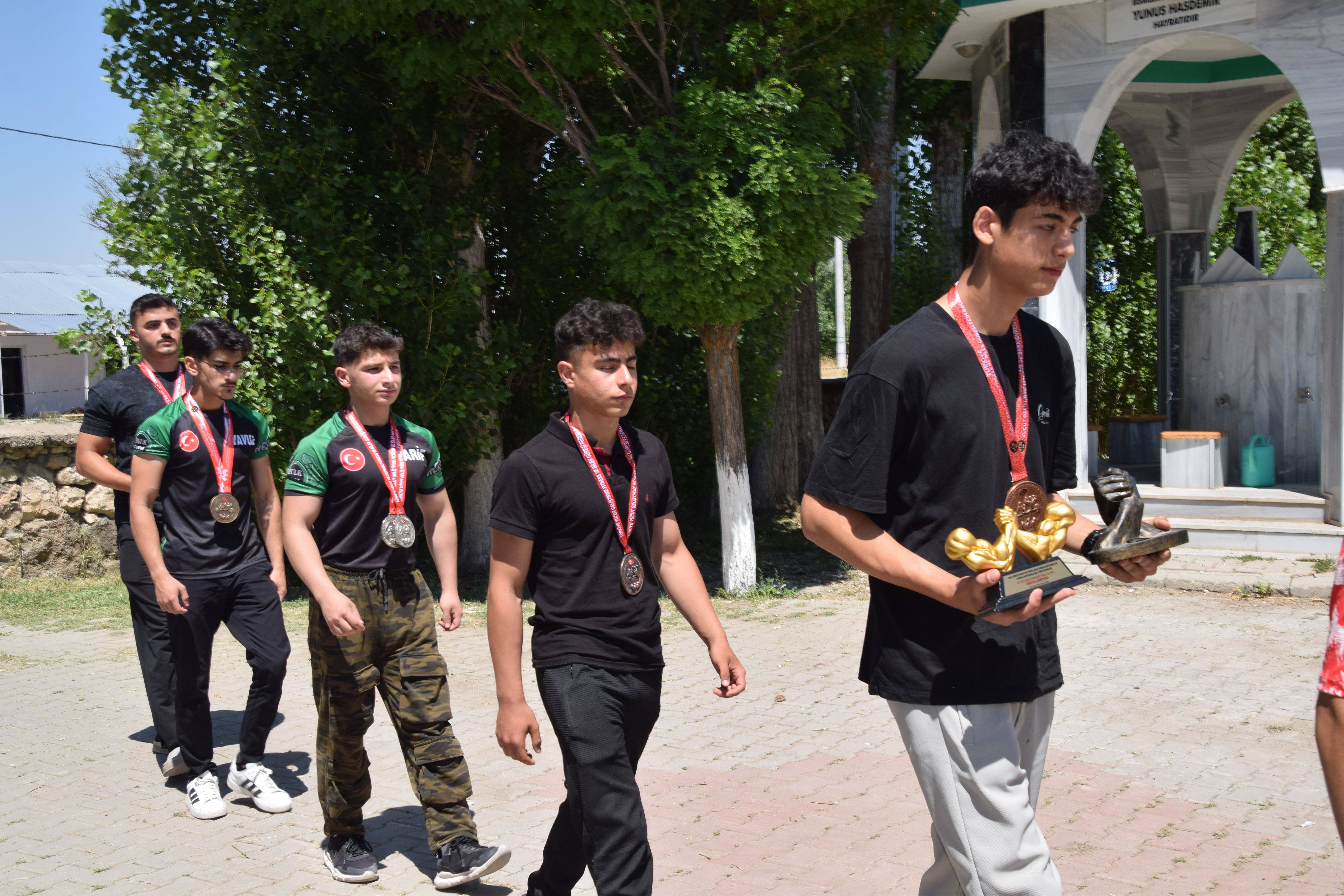 Sporcular şehit mezarı başında dua ederken
